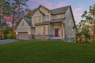 Large beige two-story house exterior idea in Other with a gray roof