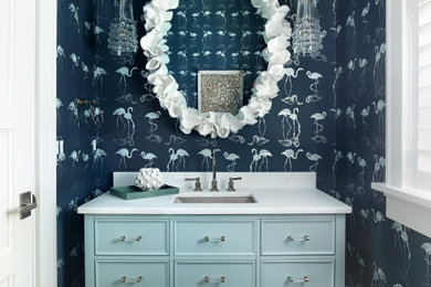 Small transitional gray tile light wood floor, beige floor, wallpaper ceiling and wallpaper powder room photo in Charleston with beaded inset cabinets, blue cabinets, gray walls, an undermount sink, marble countertops, white countertops and a floating vanity