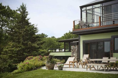 Large contemporary brown two-story mixed siding house exterior idea in Boston with a shed roof and a shingle roof