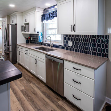 White Kitchen with Blue Tiled Backsplash and Two Tier Island
