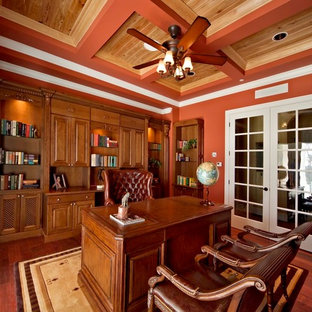 This is an example of a large modern study in San Francisco with red walls, dark hardwood flooring, no fireplace, a freestanding desk and brown floors.