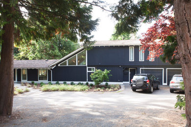 Mid-sized 1950s blue two-story stucco house exterior photo in Vancouver with a hip roof and a shingle roof
