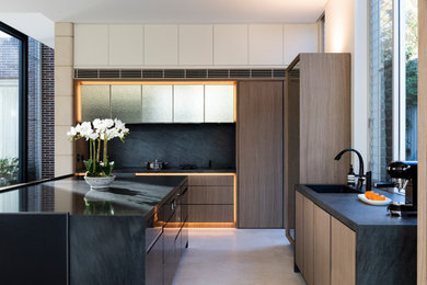 Large contemporary l-shaped kitchen in Sydney with flat-panel cabinets, medium wood cabinets, quartz benchtops, black splashback, marble splashback, stainless steel appliances, ceramic floors, with island, white floor, black benchtop and an undermount sink.