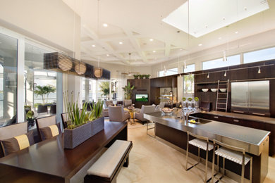 Example of a large trendy l-shaped porcelain tile and beige floor open concept kitchen design in New York with a double-bowl sink, flat-panel cabinets, stainless steel countertops, metallic backsplash, stainless steel appliances, an island and dark wood cabinets
