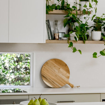 Sage green kitchen with timber floating shelves