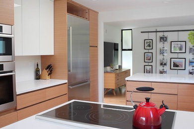 Design ideas for a large modern u-shaped eat-in kitchen in San Francisco with an undermount sink, flat-panel cabinets, light wood cabinets, quartz benchtops, stainless steel appliances and light hardwood floors.