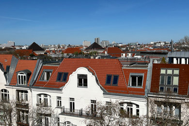 Geräumiges Modernes Wohnung mit Putzfassade, weißer Fassadenfarbe, Mansardendach, Ziegeldach und rotem Dach in Berlin