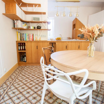 Cuisine ouverte sur l'espace de salle à manger, table circulaire en bois, chaise