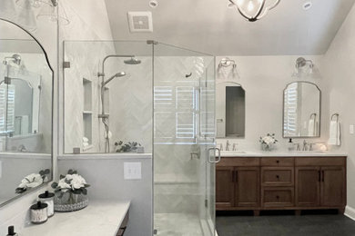 ワシントンD.C.にある高級な広いトランジショナルスタイルのおしゃれな浴室 (中間色木目調キャビネット、磁器タイルの床、クオーツストーンの洗面台、開き戸のシャワー、洗面台2つ) の写真