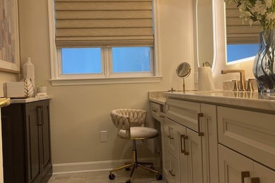 Shower bench - mid-sized coastal master beige tile and ceramic tile beige floor, double-sink and porcelain tile shower bench idea in Philadelphia with recessed-panel cabinets, beige cabinets, a two-piece toilet, beige walls, an undermount sink, granite countertops, a hinged shower door, white countertops and a built-in vanity