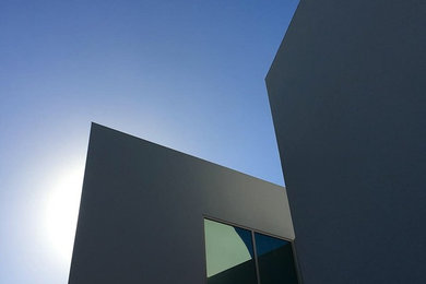 Foto de fachada de casa blanca minimalista de dos plantas con revestimiento de estuco y tejado plano