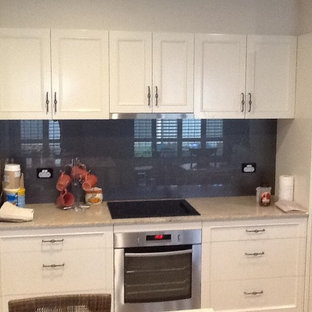 Mid-sized traditional kitchen pantry inspiration - Inspiration for a mid-sized timeless galley kitchen pantry remodel in Newcastle - Maitland with beaded inset cabinets, white cabinets, marble countertops, gray backsplash, glass sheet backsplash, stainless steel appliances and an island