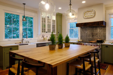 Inspiration for a large cottage u-shaped medium tone wood floor and brown floor enclosed kitchen remodel in Baltimore with a farmhouse sink, shaker cabinets, green cabinets, wood countertops, metallic backsplash, metal backsplash, stainless steel appliances, an island and brown countertops
