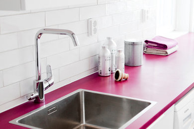 Example of a cottage chic laundry room design with a single-bowl sink, flat-panel cabinets, white cabinets, white walls and a side-by-side washer/dryer