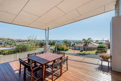 This is an example of a large modern rooftop deck in Other with a roof extension.