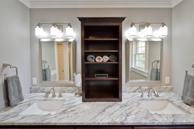 Design ideas for a large contemporary master bathroom in New York with shaker cabinets, brown cabinets, an alcove shower, a one-piece toilet, beige tile, ceramic tile, grey walls, light hardwood floors, an undermount sink, granite benchtops, brown floor, a hinged shower door and multi-coloured benchtops.