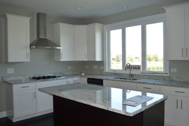 Inspiration for a craftsman u-shaped dark wood floor eat-in kitchen remodel in Chicago with an undermount sink, white cabinets, granite countertops, stainless steel appliances and an island