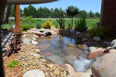 Design ideas for a mid-sized traditional partial sun backyard landscaping in Wichita.