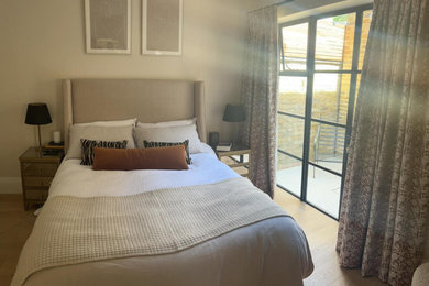 Foto de dormitorio principal minimalista grande con paredes beige, suelo de madera pintada y suelo marrón