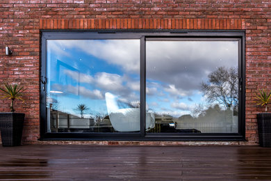 Inspiration for a mid-sized contemporary red two-story brick duplex exterior remodel in Cardiff