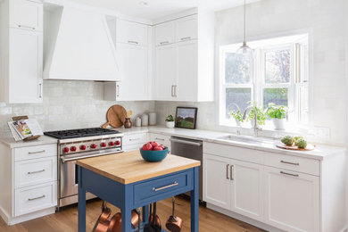 Inspiration for a mid-sized transitional u-shaped light wood floor and brown floor eat-in kitchen remodel in San Francisco with an undermount sink, shaker cabinets, white cabinets, quartz countertops, white backsplash, ceramic backsplash, stainless steel appliances, an island and white countertops