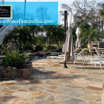 Tropical backyard room with pool waterfall, fireplace, and koi pond