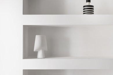 Diseño de sala de estar con biblioteca cerrada nórdica pequeña con paredes blancas y suelo de madera clara