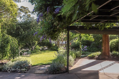 Cette photo montre un jardin avant chic de taille moyenne avec une exposition partiellement ombragée et des pavés en pierre naturelle.