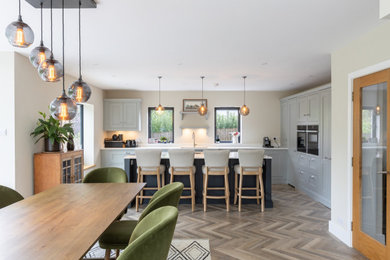 Photo of a large modern l-shaped open plan kitchen in Sussex with shaker cabinets, grey cabinets, quartzite benchtops, with island and white benchtop.