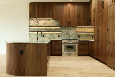 Kitchen - modern kitchen idea in Austin with flat-panel cabinets, medium tone wood cabinets, quartzite countertops and green countertops