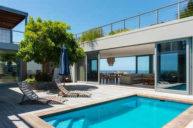 Deck - mid-sized coastal courtyard privacy deck idea in Other with a roof extension