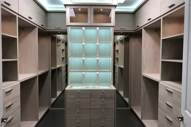 Minimalist reach-in closet photo in Miami with flat-panel cabinets and light wood cabinets