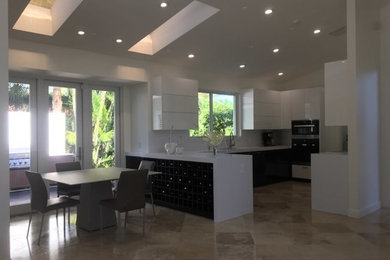 Example of a mid-sized trendy travertine floor kitchen design in Miami with flat-panel cabinets and white cabinets