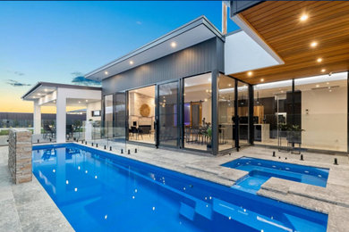 Photo of a large contemporary backyard lap pool in Canberra - Queanbeyan with a pool house.