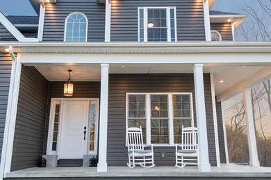 Inspiration for a large timeless concrete front porch remodel in Columbus with a roof extension