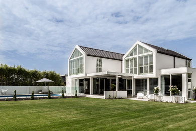 Modelo de fachada de casa blanca y negra contemporánea grande de dos plantas con tejado a dos aguas y tejado de metal