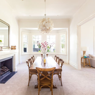 Photo of a large transitional dining room in Melbourne with white walls, carpet, a standard fireplace and a metal fireplace surround.