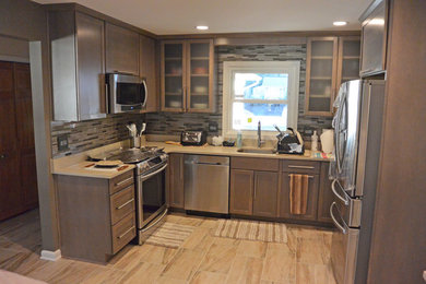 Example of a small transitional u-shaped porcelain tile and brown floor eat-in kitchen design in DC Metro with an undermount sink, shaker cabinets, gray cabinets, quartz countertops, gray backsplash, mosaic tile backsplash, stainless steel appliances, a peninsula and gray countertops