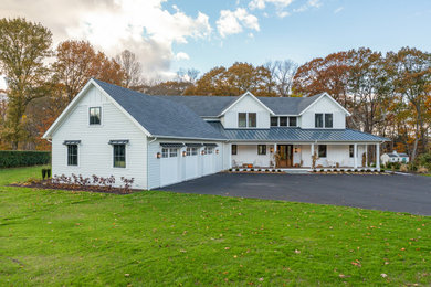 Example of a mid-sized transitional white two-story concrete fiberboard and clapboard exterior home design in Bridgeport with a mixed material roof and a gray roof
