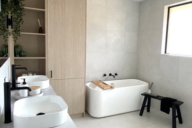 Large modern kids bathroom with flat-panel cabinets, light wood cabinets, a freestanding tub, an open shower, white tile, mosaic tile, concrete benchtops, grey benchtops, a double vanity and a floating vanity.