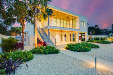 Inspiration for a mid-sized modern white two-story stucco flat roof remodel in Tampa