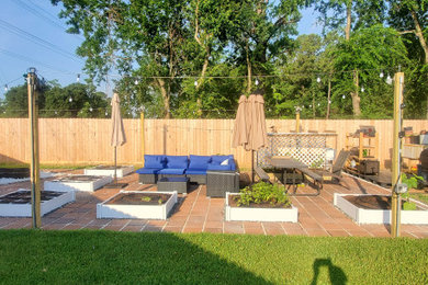 Example of a backyard concrete paver patio vegetable garden design in Houston