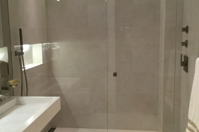 Mid-sized minimalist master beige tile and ceramic tile ceramic tile alcove shower photo in New York with a wall-mount sink, a wall-mount toilet and beige walls