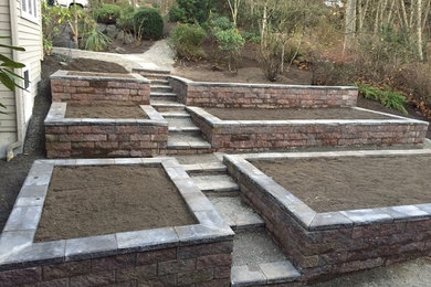 Photo of a large traditional backyard partial sun formal garden in Seattle with a retaining wall.