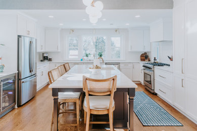 Example of a large transitional u-shaped medium tone wood floor eat-in kitchen design in Philadelphia with an undermount sink, shaker cabinets, white cabinets, white backsplash, stainless steel appliances, an island and white countertops