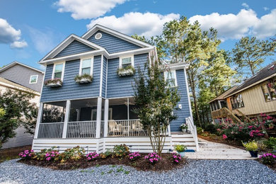 Example of a mid-sized beach style blue two-story exterior home design in Other