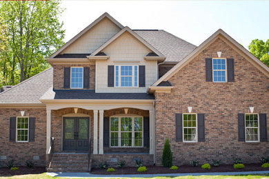 Example of a mid-sized classic beige two-story mixed siding gable roof design in Raleigh