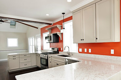 Mid-sized transitional u-shaped dark wood floor eat-in kitchen photo in Portland Maine with an undermount sink, flat-panel cabinets, beige cabinets, quartz countertops, beige backsplash, stainless steel appliances and no island