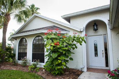Inspiration for a large beach style one-storey stucco white exterior in Miami with a gable roof.