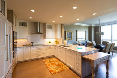 Inspiration for a large transitional u-shaped brown floor and medium tone wood floor open concept kitchen remodel in Denver with an undermount sink, shaker cabinets, white cabinets, granite countertops, white backsplash, mosaic tile backsplash, stainless steel appliances and a peninsula